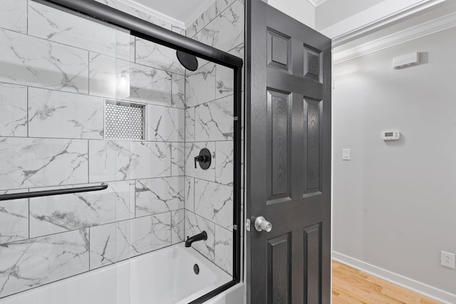 full bathroom with bath / shower combo with glass door, ornamental molding, baseboards, and wood finished floors