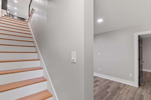 stairs with baseboards, recessed lighting, and wood finished floors