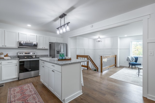 kitchen featuring white cabinetry, dark hardwood / wood-style flooring, a kitchen island, and appliances with stainless steel finishes