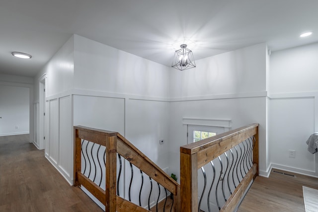 hallway with dark hardwood / wood-style flooring and a chandelier