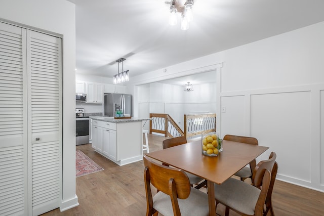 dining space featuring light hardwood / wood-style floors and a notable chandelier