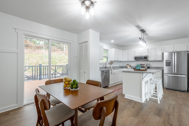 dining space with light wood-type flooring and sink