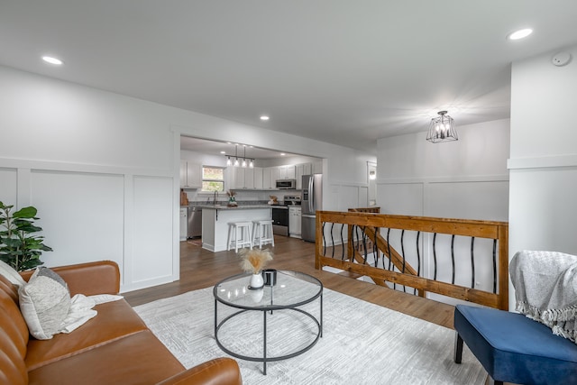 living room featuring dark hardwood / wood-style flooring, a notable chandelier, and sink