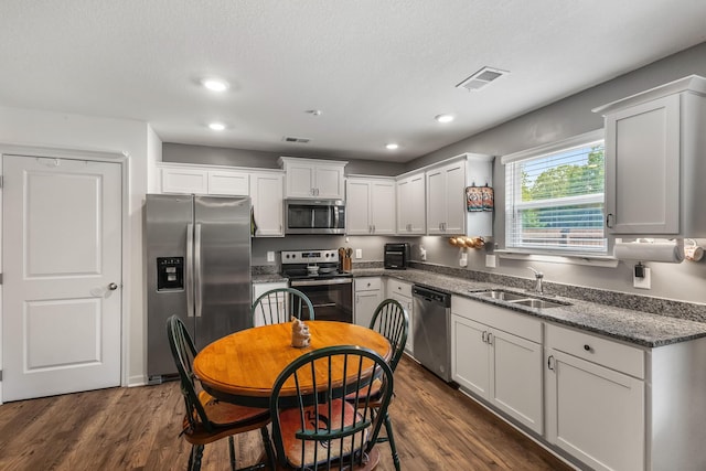 115 Belle Way, Athens, TN 37303 - kitchen with appliances with stainless steel finishes, dark wood-style flooring, white cabinetry, dark stone countertops, and recessed lighting