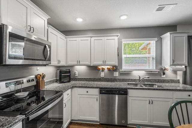 115 Belle Way, Athens, TN 37303 - kitchen featuring appliances with stainless steel finishes, white cabinetry, dark stone countertops, and recessed lighting
