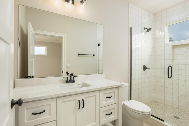 bathroom featuring walk in shower, vanity, toilet, and a wealth of natural light