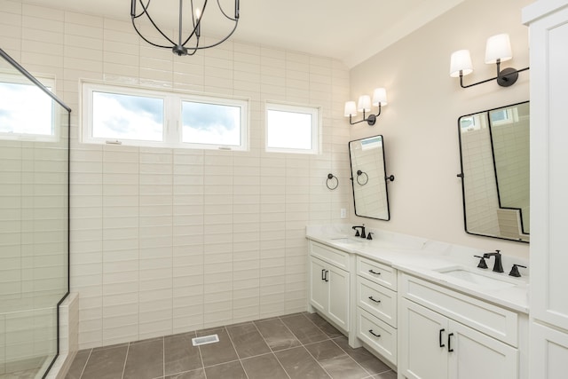 bathroom featuring vanity, a shower with door, and tile walls