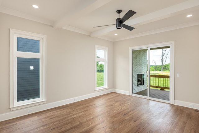 unfurnished room featuring beamed ceiling, hardwood / wood-style flooring, a wealth of natural light, and ceiling fan