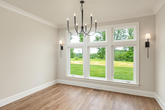 unfurnished dining area with ornamental molding, light hardwood / wood-style flooring, and an inviting chandelier