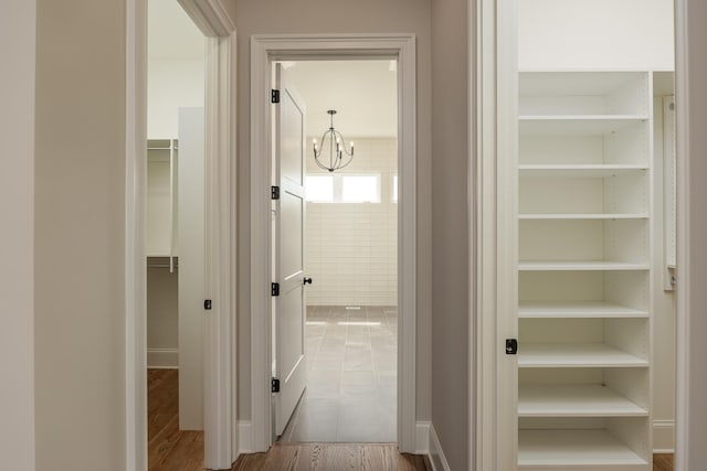 hallway featuring hardwood / wood-style floors and an inviting chandelier