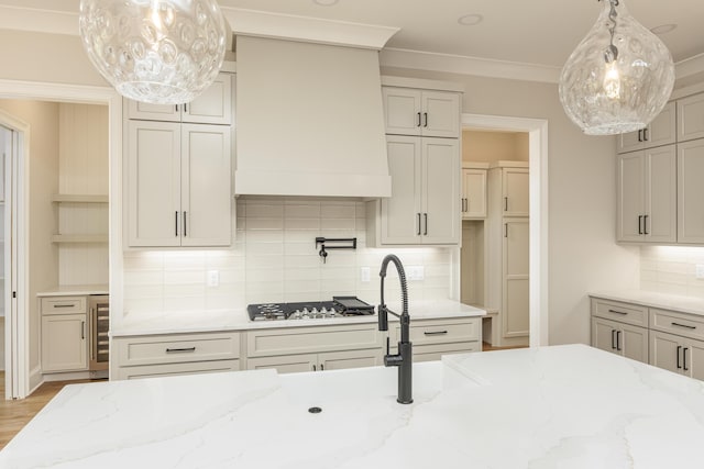 kitchen featuring beverage cooler, light stone countertops, backsplash, and stainless steel gas cooktop