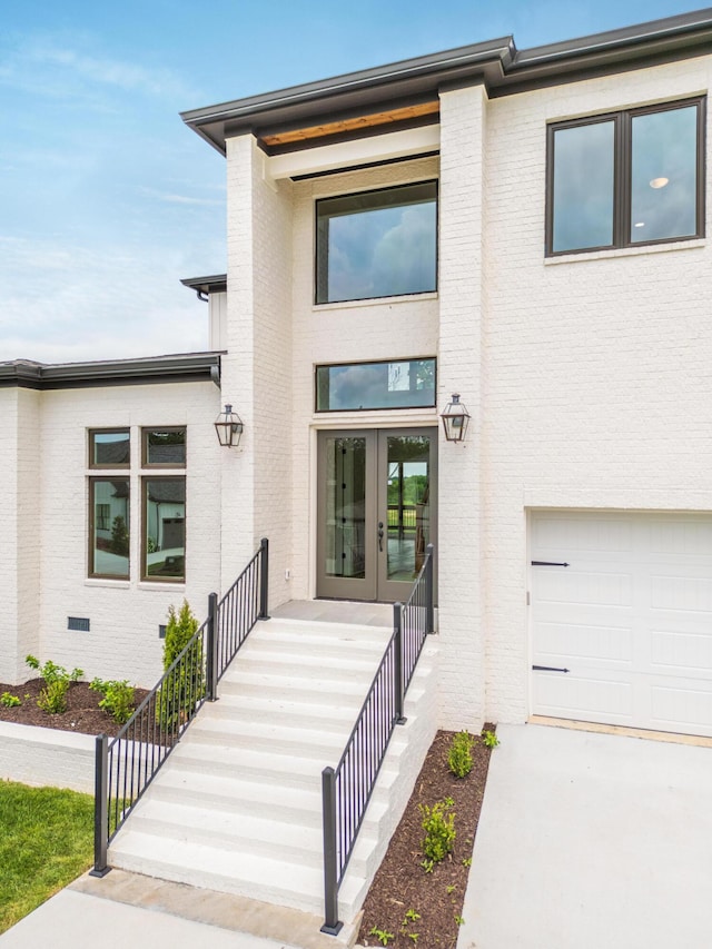 view of exterior entry featuring french doors and a garage