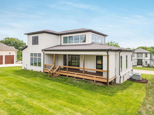 rear view of property with central air condition unit and a lawn