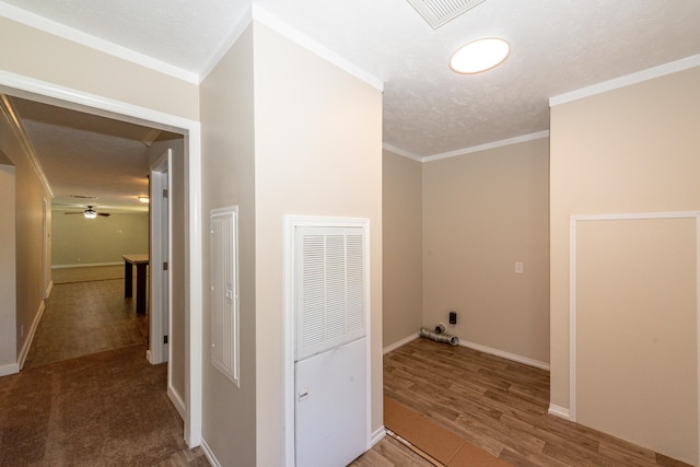 corridor featuring hardwood / wood-style flooring, crown molding, and a textured ceiling