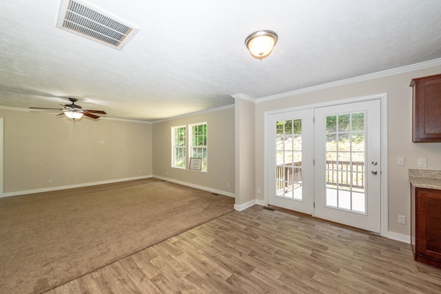 unfurnished living room featuring ceiling fan, ornamental molding, and light hardwood / wood-style flooring