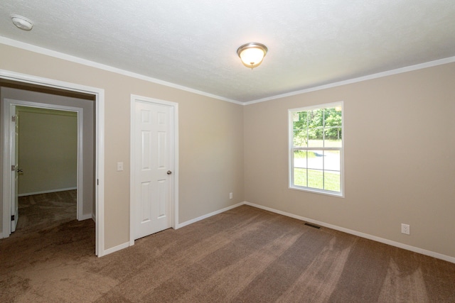 carpeted empty room featuring crown molding