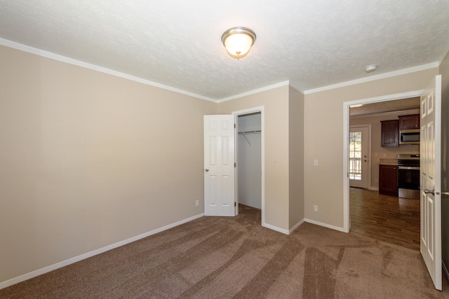 unfurnished bedroom featuring carpet flooring, a closet, a textured ceiling, and ornamental molding