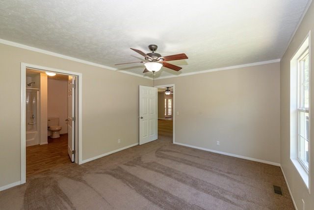 unfurnished bedroom with ensuite bath, ceiling fan, and ornamental molding