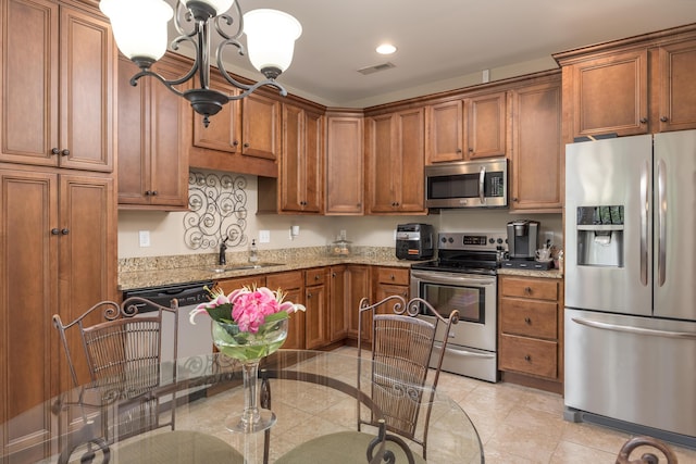 1726 Derby Ln NW, Cleveland, TN 37312 - kitchen featuring appliances with stainless steel finishes, brown cabinetry, a chandelier, light stone countertops, and recessed lighting