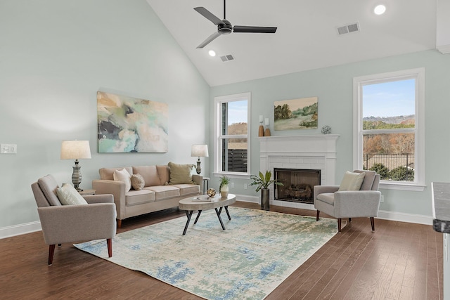 living room with ceiling fan, a fireplace, high vaulted ceiling, and dark hardwood / wood-style floors