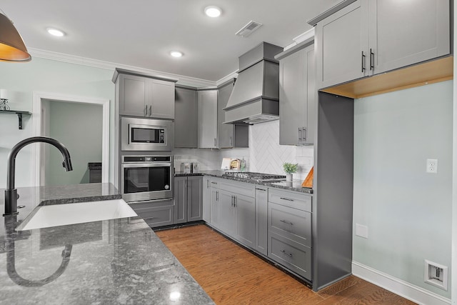 kitchen featuring gray cabinets, sink, stainless steel appliances, and custom range hood