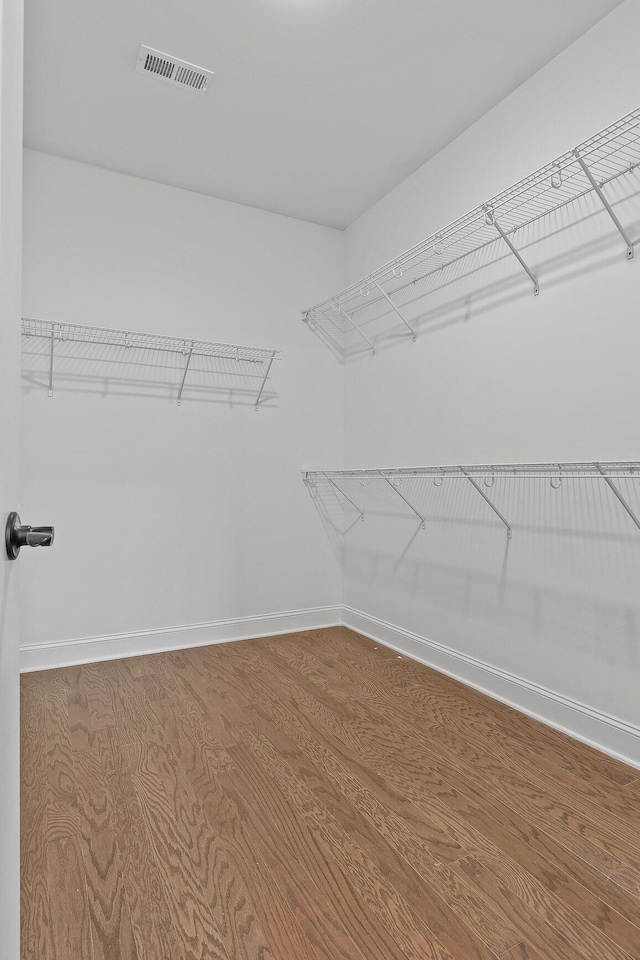 walk in closet with hardwood / wood-style floors