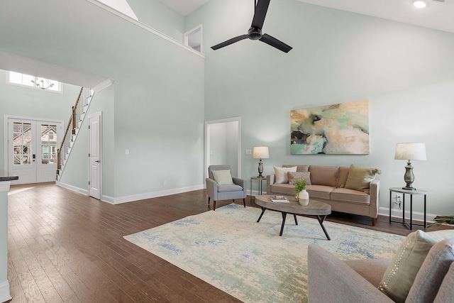 living room featuring dark hardwood / wood-style flooring, ceiling fan, french doors, and a high ceiling