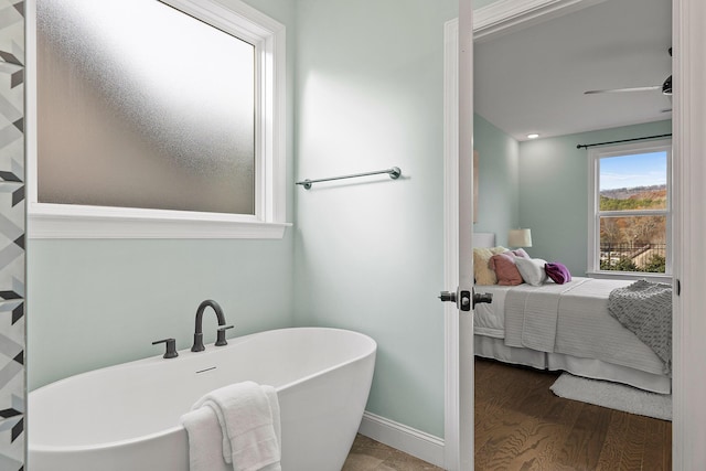 bathroom featuring hardwood / wood-style floors, a bathtub, and ceiling fan