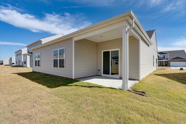 back of property featuring a lawn and a patio area