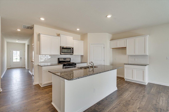 kitchen with white cabinets, sink, dark hardwood / wood-style floors, an island with sink, and stainless steel appliances