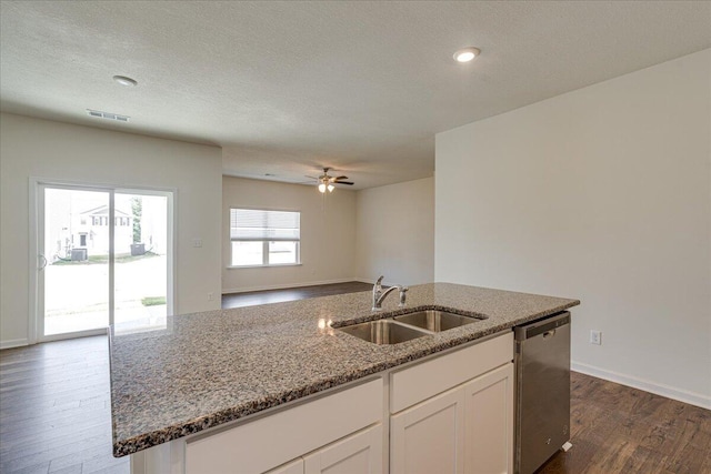 kitchen featuring stainless steel dishwasher, dark wood-type flooring, sink, a center island with sink, and white cabinets