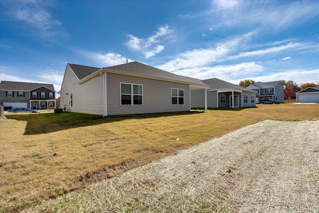 view of front of house with cooling unit and a front lawn