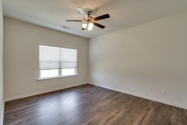 spare room with a textured ceiling, dark hardwood / wood-style floors, and ceiling fan