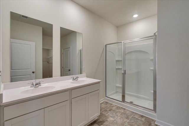 bathroom with a shower with door and vanity