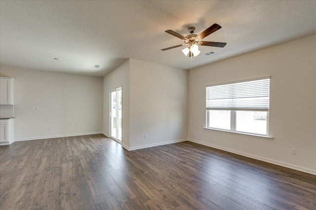 unfurnished living room with dark hardwood / wood-style floors, ceiling fan, and a textured ceiling