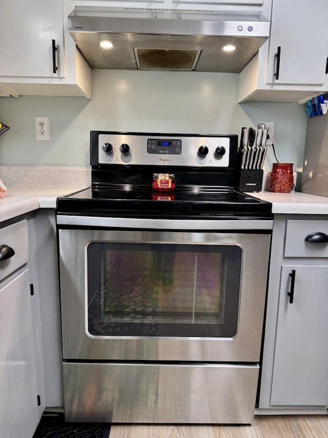 kitchen with white cabinetry, light countertops, stainless steel range with electric stovetop, and under cabinet range hood