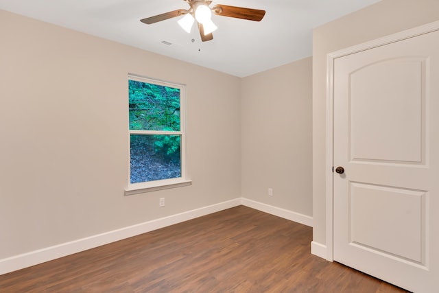 empty room with ceiling fan and dark hardwood / wood-style flooring