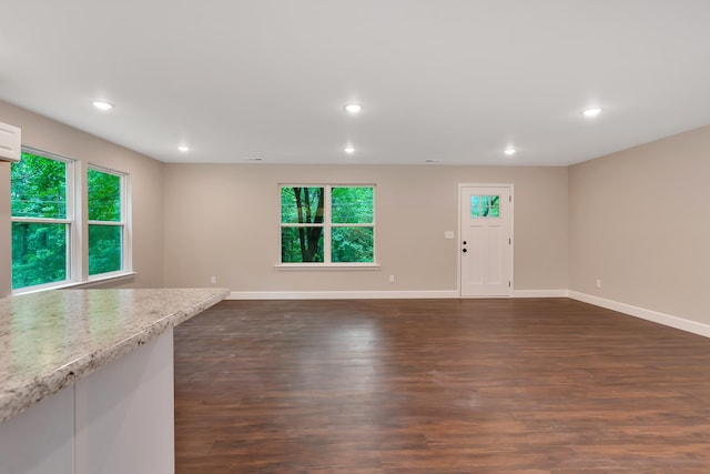 unfurnished living room with dark hardwood / wood-style flooring and a wall mounted AC