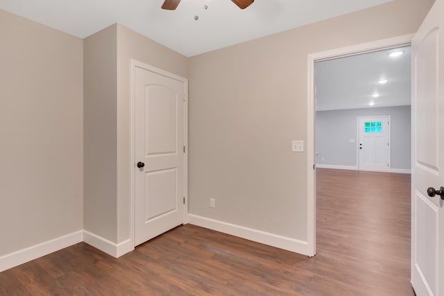 unfurnished room featuring ceiling fan and dark wood-type flooring