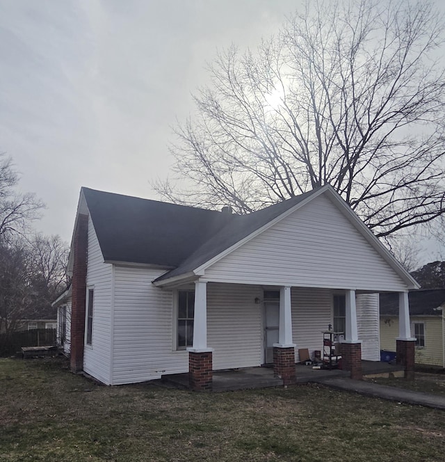 view of front of house featuring covered porch and a front lawn