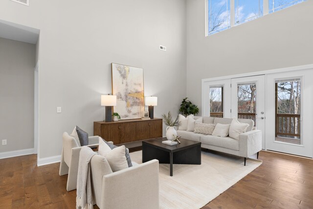 living room featuring a high ceiling and dark hardwood / wood-style floors