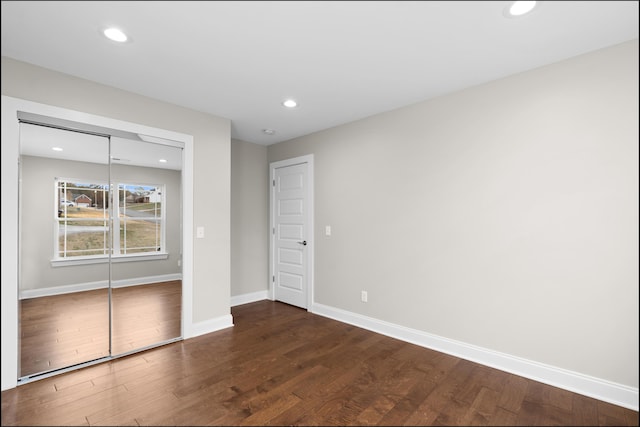 unfurnished bedroom featuring a closet and dark hardwood / wood-style floors