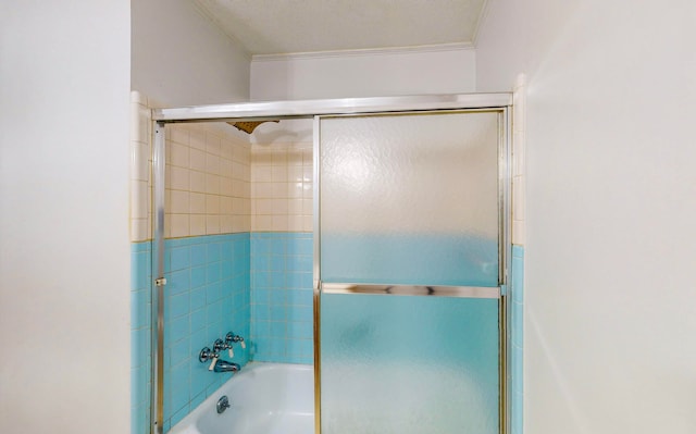 bathroom featuring enclosed tub / shower combo, a textured ceiling, and ornamental molding