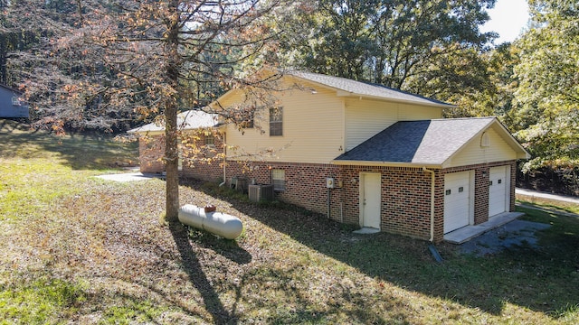 view of property exterior with a lawn, cooling unit, and a garage