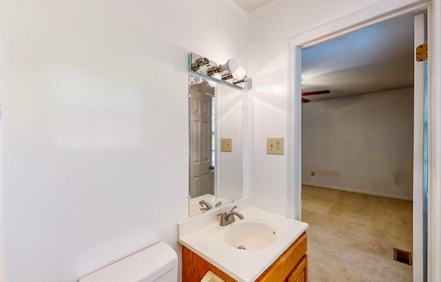 bathroom with vanity, toilet, and ornamental molding