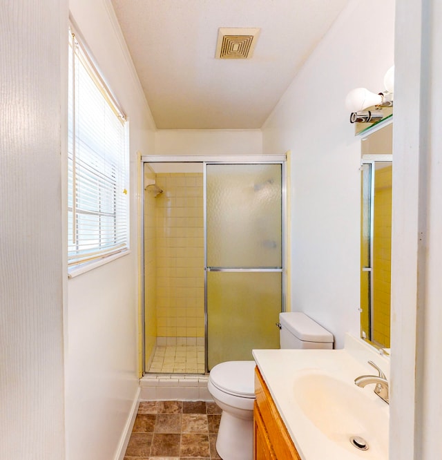 bathroom featuring tile patterned flooring, vanity, toilet, and walk in shower