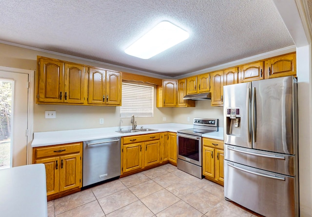 kitchen with light tile patterned flooring, a textured ceiling, stainless steel appliances, and sink