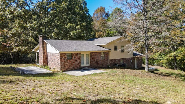 tri-level home featuring a patio and a front lawn