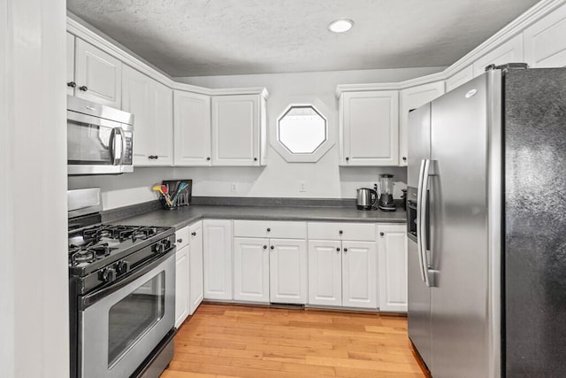 5027 Fanchers Mill Rd, Sparta, TN 38583 - kitchen with appliances with stainless steel finishes, dark countertops, white cabinetry, light wood-type flooring, and recessed lighting