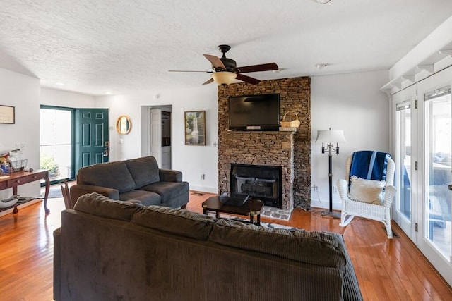 5027 Fanchers Mill Rd, Sparta, TN 38583 - living area with ceiling fan, wood finished floors, a stone fireplace, and a textured ceiling